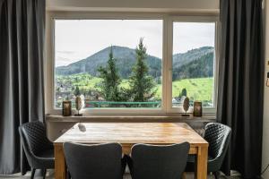 a dining room with a table and a large window at Apartment Schwarzwald Panorama in Baden-Baden
