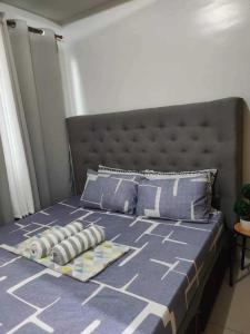 uma cama com um edredão azul e almofadas em Shell Residences condotel em Manila