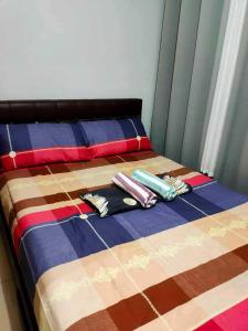 uma cama com cobertores coloridos e almofadas em Shell Residences condotel em Manila