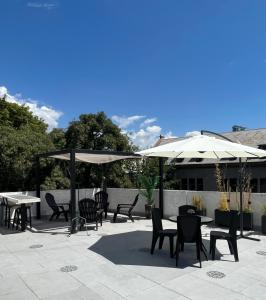 un patio con mesas, sillas y sombrillas en Terrazas de Rondeau en Mendoza