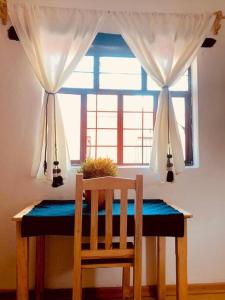 uma mesa com uma cadeira em frente a uma janela em Casa Matilda San Cristobal em San Cristóbal de Las Casas