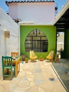 um pátio com cadeiras, uma mesa e uma parede verde em Casa Matilda San Cristobal em San Cristóbal de Las Casas