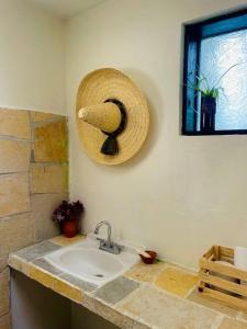 uma casa de banho com um lavatório e um chapéu de palha na parede em Casa Matilda San Cristobal em San Cristóbal de Las Casas