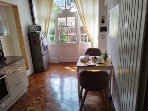 uma cozinha com uma mesa com 2 cadeiras e um frigorífico em Ferienwohnung - a66157 em Leiwen