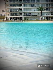 una grande piscina d'acqua di fronte a un edificio di Bella casa de playa Mar Adentro a Santa Cruz de la Sierra