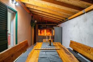 einen langen Holztisch in einem Zimmer mit Bänken in der Unterkunft Villa Viktoria in Donji Muć