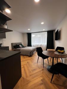 eine Küche und ein Wohnzimmer mit einem Tisch und einem Bett in der Unterkunft Hygge Apartments in Druskininkai