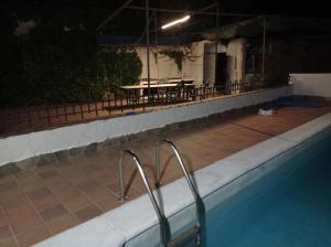 a swimming pool at night with a table and chairs at Chalet Venta del Aire in Lanjarón