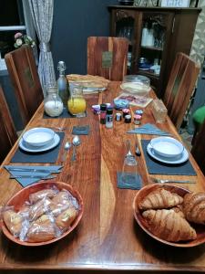 una mesa de madera con platos de comida y pan. en Cherry Blossom House, en Bujaleuf