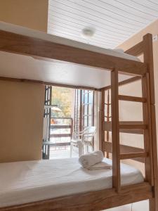 a bunk bed in a room with a balcony at Água Doce Praia Hotel in Ubatuba