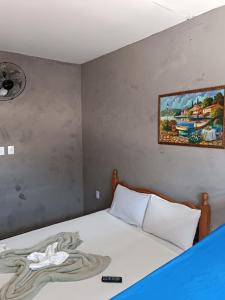 a bedroom with a bed with a painting on the wall at Hostel365 in Angra dos Reis
