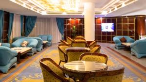 a waiting room with chairs and tables and a tv at White Valley Palace in Hurghada