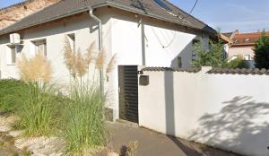 a white house with a white fence at Bogyó Family Land Budapest in Budapest