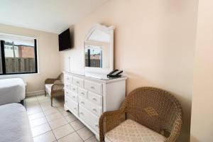 a bedroom with a dresser and a mirror at Bright Modern Room First Floor Resort View in Pawleys Island