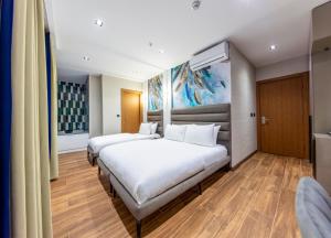 a bedroom with two beds and a painting on the wall at Dem Premium Hotel - Round Trip Airport Service - Istanbul International Airport in Arnavutköy