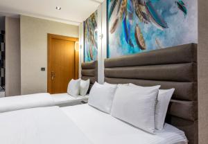 a bedroom with a large bed with white pillows at Dem Premium Hotel - Round Trip Airport Service - Istanbul International Airport in Arnavutköy