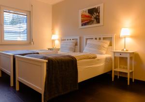 1 Schlafzimmer mit 2 Betten, 2 Lampen und einem Fenster in der Unterkunft Hotel zum Postwagen in Gevelsberg