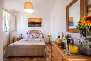 ein Schlafzimmer mit einem Bett und einem Tisch mit Blumen in der Unterkunft Room in Holiday house - Relais Torre Chianca With Climate, Parking, Wi-Fi Panoramic Rooftop in Porto Cesareo