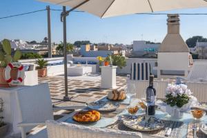 einen Tisch mit Teller mit Lebensmitteln auf dem Dach in der Unterkunft Room in Holiday house - Relais Torre Chianca With Climate, Parking, Wi-Fi Panoramic Rooftop in Porto Cesareo