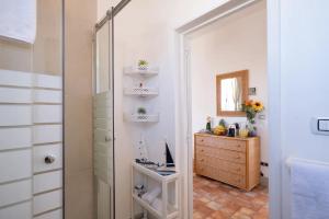 ein Bad mit einer Dusche, einer Kommode und einem Spiegel in der Unterkunft Room in Holiday house - Relais Torre Chianca With Climate, Parking, Wi-Fi Panoramic Rooftop in Porto Cesareo
