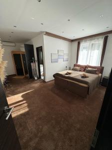 a large bedroom with a bed and a large window at Bogyó Family Land Budapest in Budapest