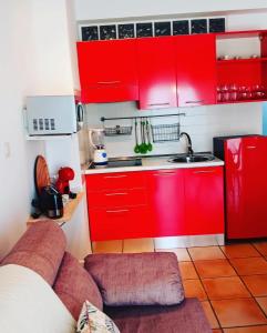 una cocina roja con armarios rojos y fregadero en Playa Velilla Velimar 2, en Almuñécar