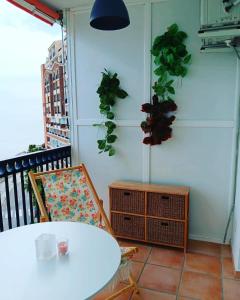 una mesa y una silla en un balcón con plantas en Playa Velilla Velimar 2 en Almuñécar