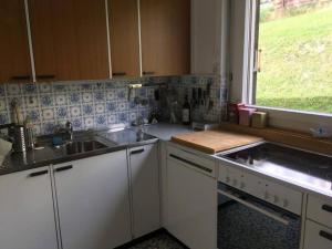 a kitchen with white cabinets and a sink and a window at Casa Splendusa - sonnige Wohnung in Brigels in Breil/Brigels