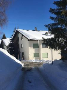 a house with a snow covered roof on a snowy street at Casa Splendusa - sonnige Wohnung in Brigels in Breil/Brigels