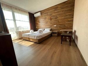 斯特雷恰的住宿－Бонита Хотел Спа，一间卧室设有一张床和木墙