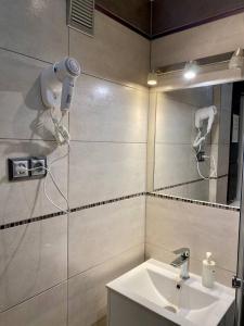 ein Bad mit einem Waschbecken und einem Spiegel in der Unterkunft HALBY rooms Rondo ONZ in Warschau
