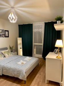 ein Schlafzimmer mit einem Bett und einem grünen Vorhang in der Unterkunft HALBY rooms Rondo ONZ in Warschau