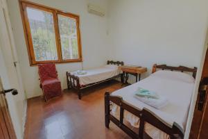 een kamer met 2 bedden, een stoel en een raam bij Los Troncos TownHomes in Cordoba +27 foto's