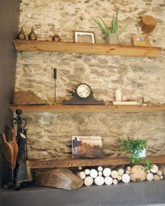 une étagère avec une horloge sur un mur en pierre dans l'établissement Espectacular Chalet de Montaña Pirineos, Burg, à Burg