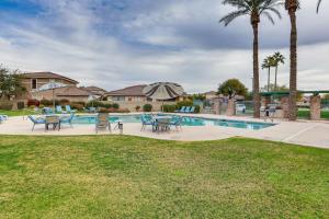 a pool with tables and chairs and palm trees at Goodyear Home with Private Patio and Golf Course View in Goodyear