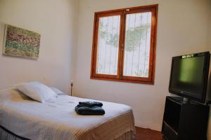 een slaapkamer met een bed, een tv en een raam bij Los Troncos TownHomes in Cordoba