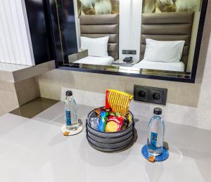 a bathroom with a basket of candy and two bottles at Dem Premium Hotel - Round Trip Airport Service - Istanbul International Airport in Arnavutköy