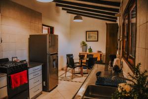 een keuken met een koelkast en een tafel met stoelen bij Los Troncos TownHomes in Cordoba