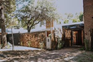 een bakstenen gebouw met een poort en een boom bij Los Troncos TownHomes in Cordoba