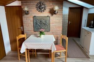 a dining room with a table and chairs and a brick wall at Ferienwohnung Deininger inkl. Chiemgaukarte in Ruhpolding