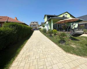 a brick walkway in a yard next to houses at Rena Vendégház in Nagykanizsa