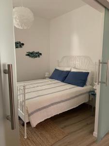 a bedroom with a white bed with blue pillows at Cuore di Lerici , amazing view in Lerici