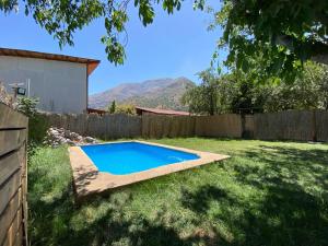 un patio trasero con una piscina en el césped en Cabaña en San Jose de Maipo, en Melocotón