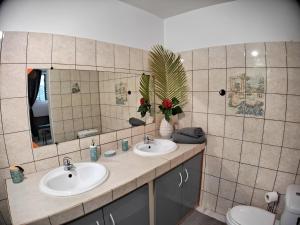 La salle de bains est pourvue de 2 lavabos et d'un miroir. dans l'établissement Couleurs caraïbes - Plage et Tranquillité, à Sainte-Anne