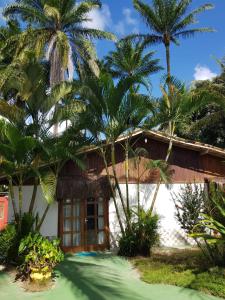 una casa con palmeras delante en Pousada Pérola do Atlântico, en Isla de Boipeba