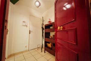 a red door in a room with a shelf at Appartement 1 chambre Les Lumières avec parking sous-sol in Chartres