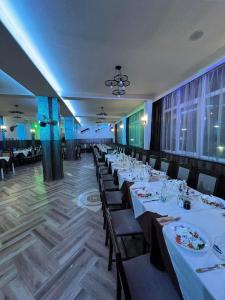 una sala da pranzo con tavoli e sedie con tovaglie bianche di Бонита Хотел Спа a Strelcha