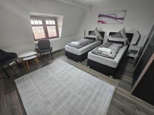 a bedroom with two beds and a table and chairs at Suite Dari in Bernburg