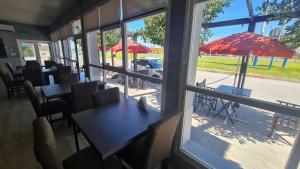 a restaurant with tables and chairs and umbrellas at Club House Hotel in General Roca