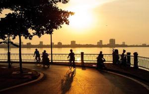 een groep mensen die fietsen voor het water bij H2B WESTLAKE in Hanoi